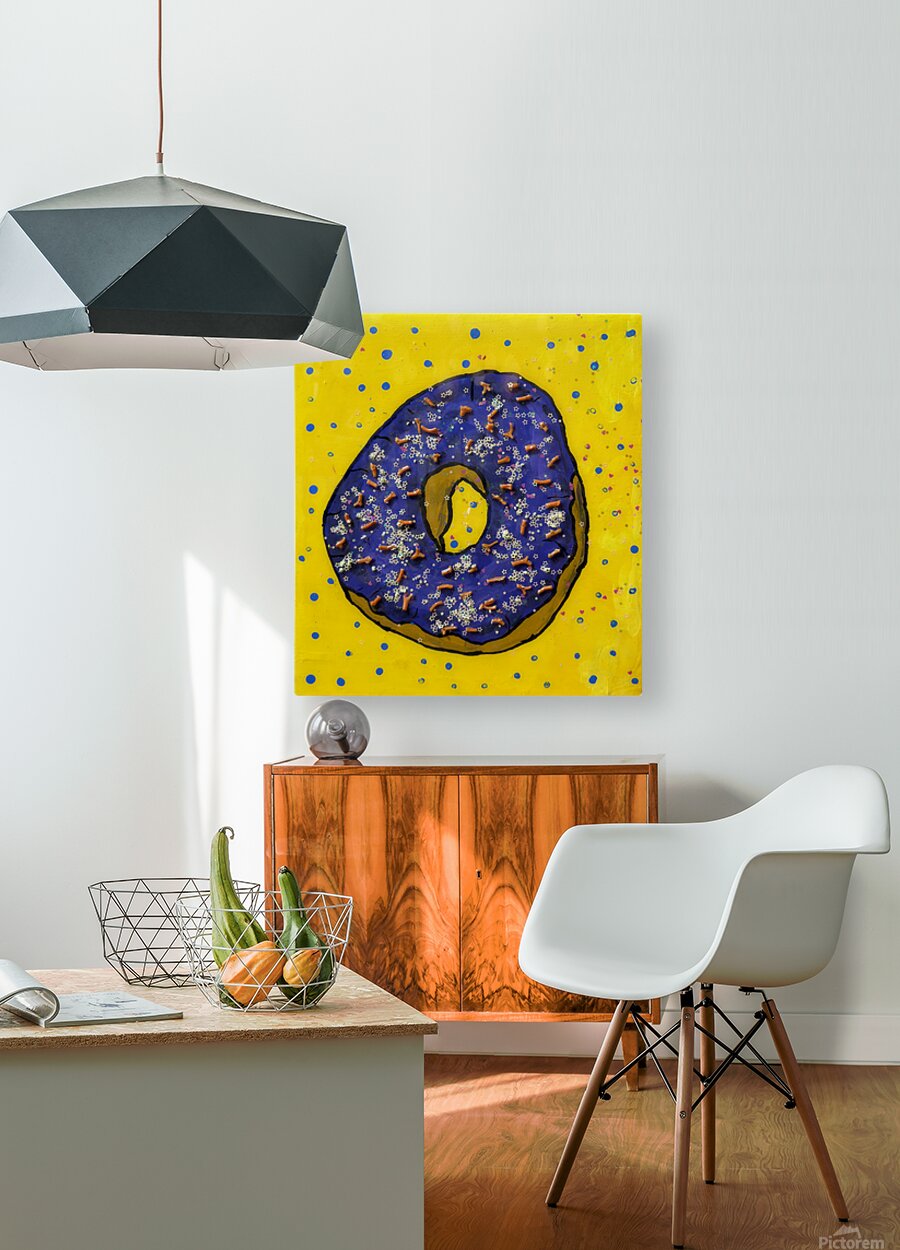 Bright colorful pop art print, in a home, featuring a whimsical purple donut with glitter on a vibrant yellow background.